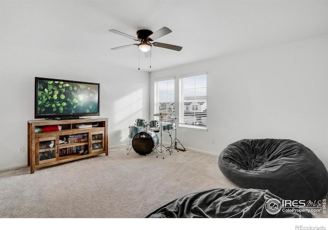 living area featuring carpet floors and ceiling fan