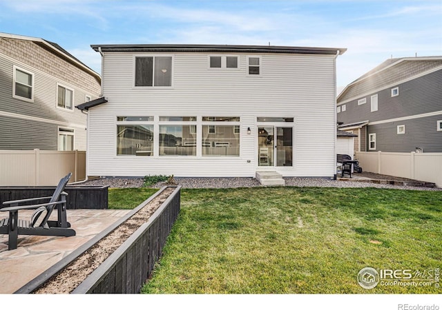 back of property with a lawn and a patio area