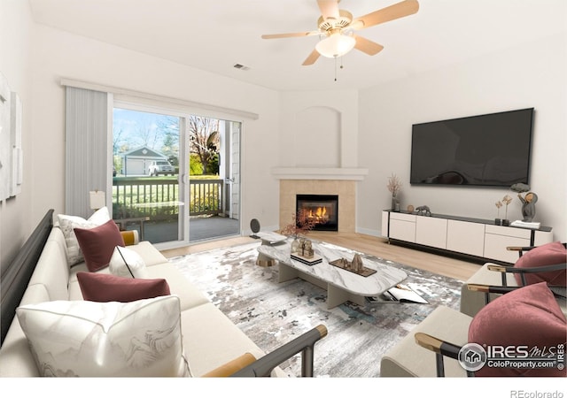 living room featuring baseboards, visible vents, a ceiling fan, wood finished floors, and a fireplace