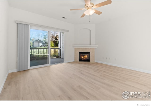 unfurnished living room with baseboards, a fireplace, visible vents, and wood finished floors