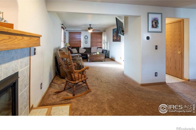 carpeted living room with a fireplace and ceiling fan