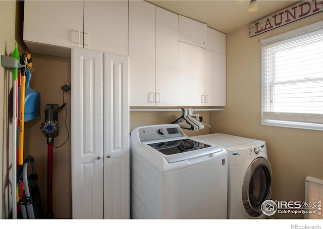 clothes washing area with cabinets and independent washer and dryer