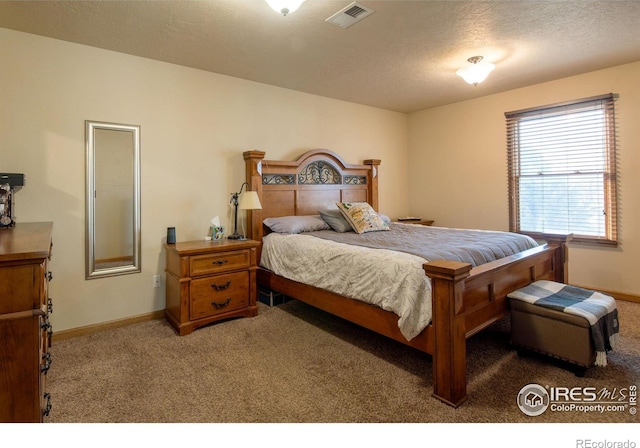 bedroom with a textured ceiling and carpet floors