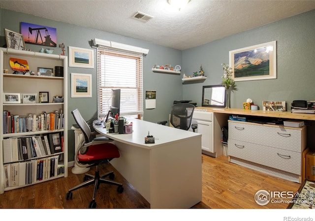 office space featuring light hardwood / wood-style floors and a textured ceiling