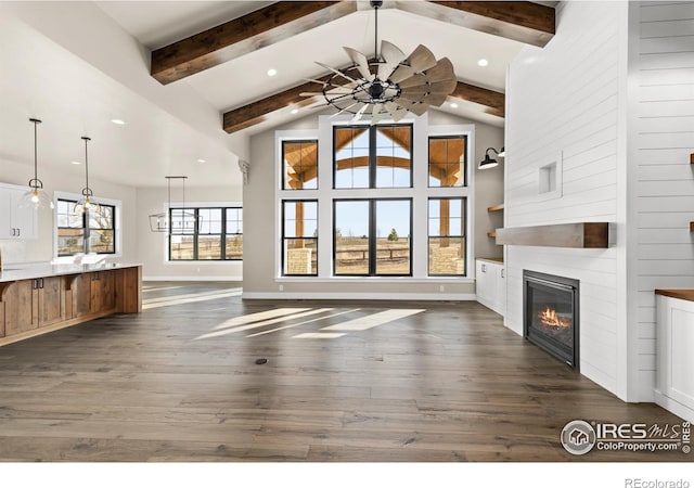 unfurnished living room featuring beam ceiling, a fireplace, high vaulted ceiling, and dark hardwood / wood-style floors