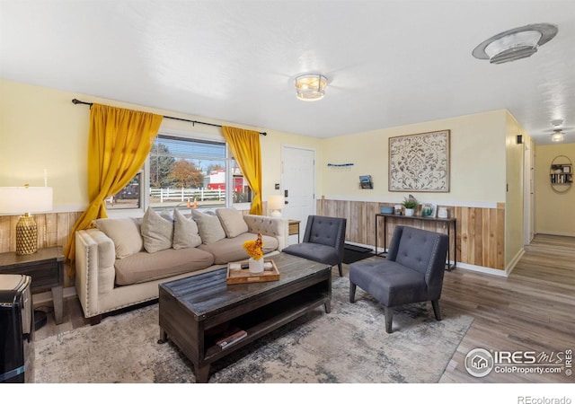 living room featuring hardwood / wood-style floors and wooden walls