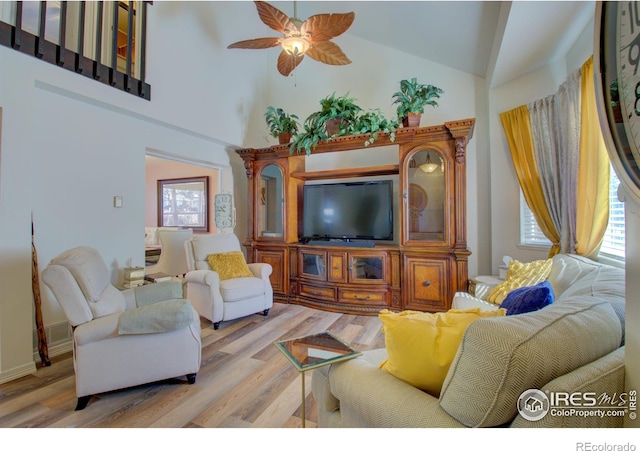 living room with ceiling fan, light wood-type flooring, and high vaulted ceiling