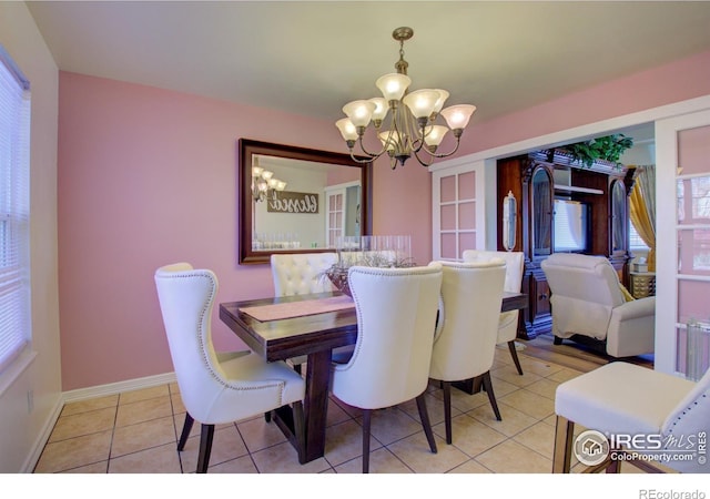 dining space with light tile patterned flooring and an inviting chandelier