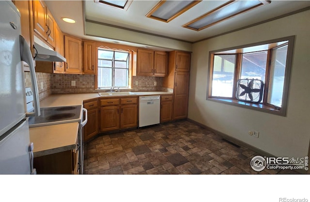 kitchen featuring white appliances, backsplash, and sink