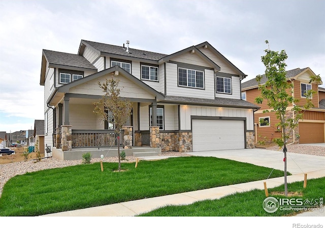 708 85th Avenue Ct, Greeley, CO 80634 - view of front of house featuring an attached garage, stone siding, driveway, a porch, and a front yard