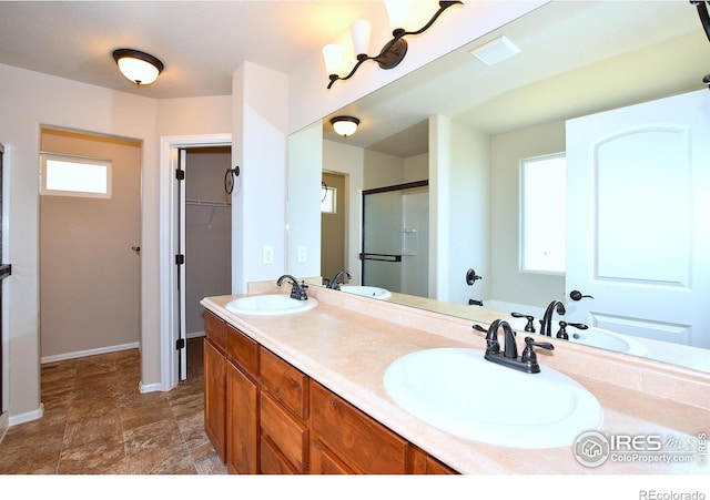 708 85th Avenue Ct, Greeley, CO 80634 - bathroom with a shower stall, plenty of natural light, double vanity, and baseboards