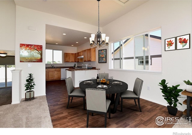 dining area with sink, dark wood-type flooring, and a notable chandelier