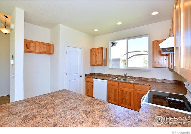 kitchen with white appliances, brown cabinets, under cabinet range hood, a sink, and recessed lighting