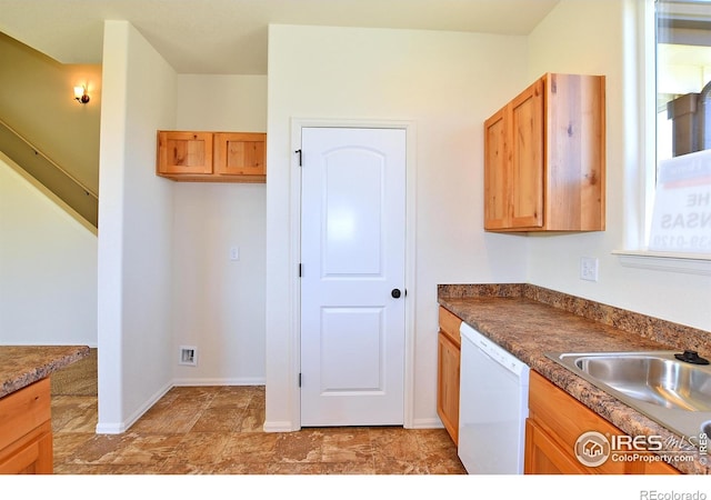 kitchen featuring a sink, dark countertops, baseboards, and dishwasher