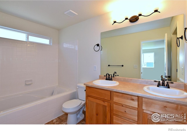 full bathroom featuring visible vents, a sink, toilet, and double vanity