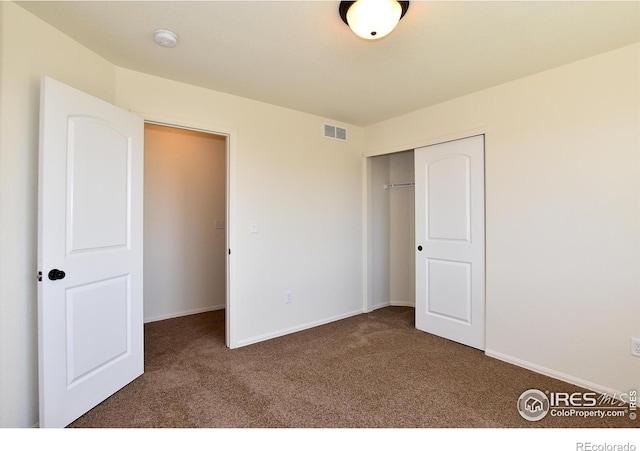 unfurnished bedroom with baseboards, carpet, visible vents, and a closet