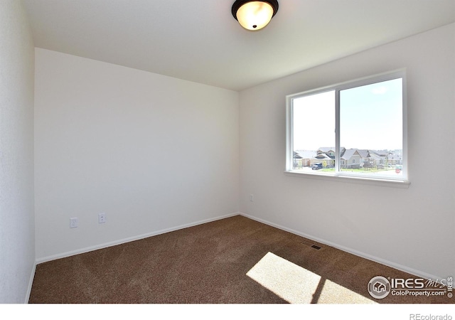 carpeted empty room featuring visible vents and baseboards