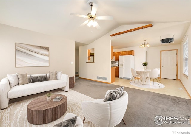 carpeted living room featuring vaulted ceiling and ceiling fan with notable chandelier