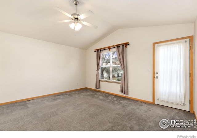 carpeted empty room featuring vaulted ceiling and ceiling fan