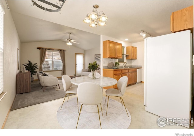 dining space with ceiling fan, sink, and vaulted ceiling