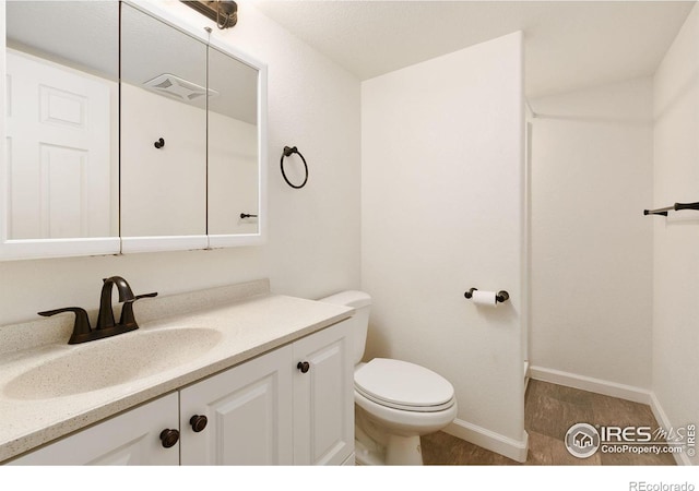 bathroom featuring hardwood / wood-style flooring, toilet, and vanity