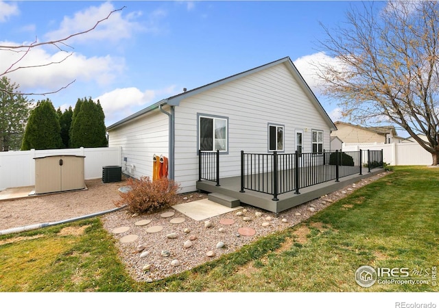 back of house featuring a lawn, a deck, and cooling unit