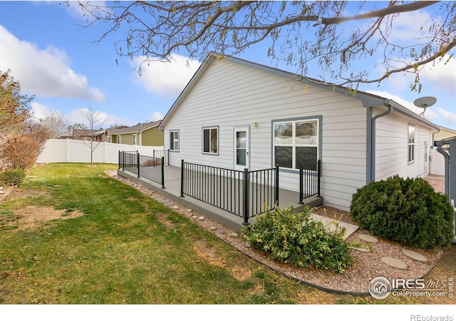 rear view of property with a lawn