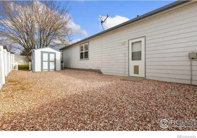 rear view of house featuring a storage unit