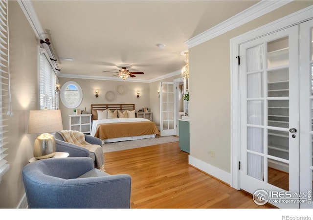 bedroom with french doors, hardwood / wood-style flooring, ceiling fan, and crown molding