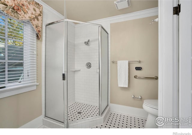 bathroom with a shower with door, tile patterned flooring, and toilet