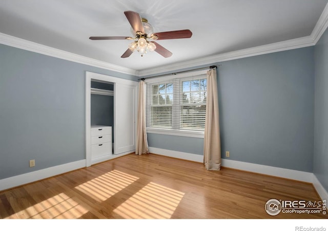 unfurnished bedroom featuring a closet, ceiling fan, crown molding, and light hardwood / wood-style floors