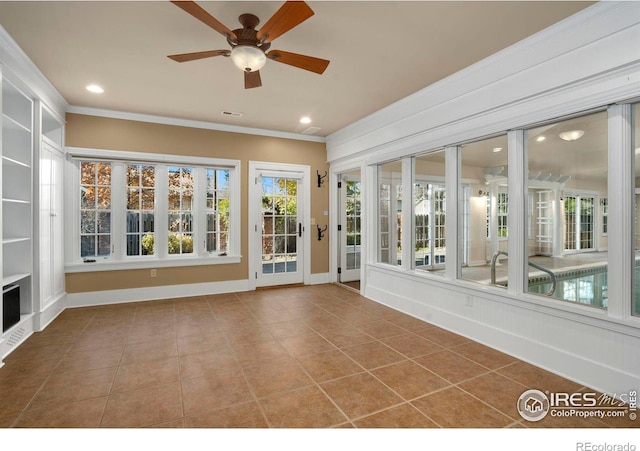 unfurnished sunroom featuring ceiling fan