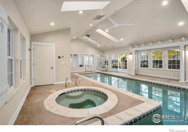 view of swimming pool featuring a skylight, ceiling fan, and an indoor in ground hot tub