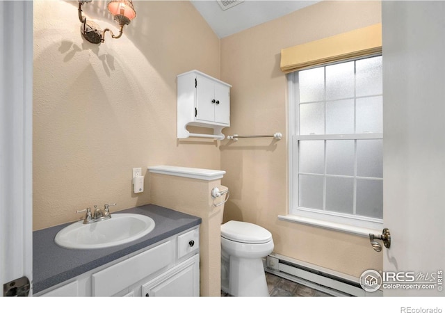 bathroom with vanity, toilet, and baseboard heating