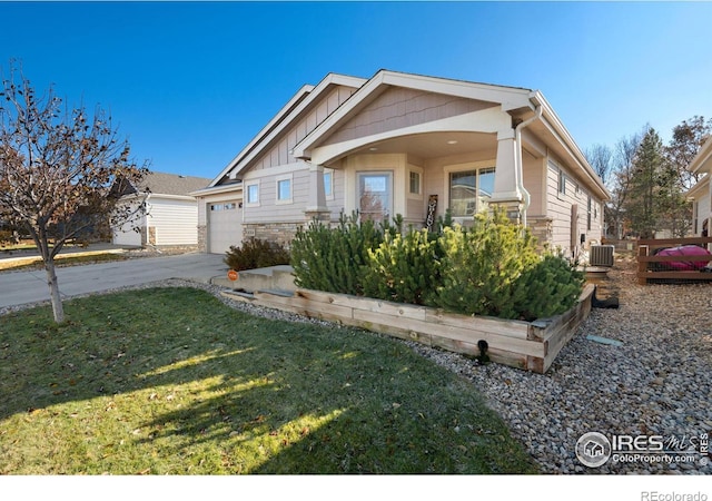 view of front of home with a front yard, a garage, and central AC unit