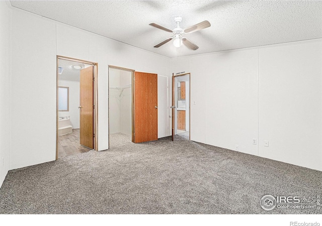 unfurnished bedroom featuring carpet, a textured ceiling, ensuite bath, and ceiling fan