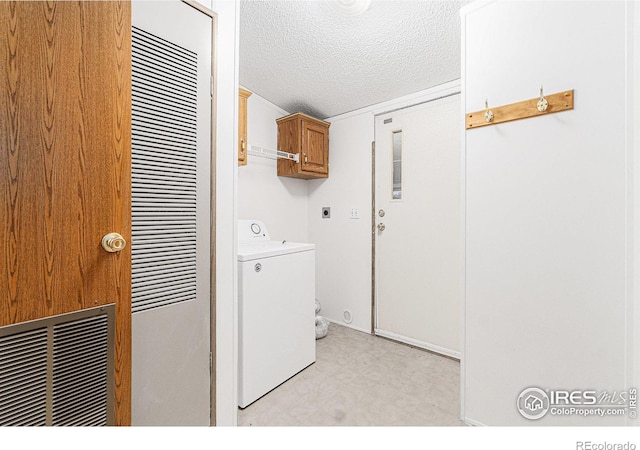 washroom featuring cabinets, washer / dryer, and a textured ceiling