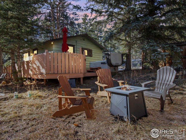 exterior space with a wooden deck and an outdoor fire pit