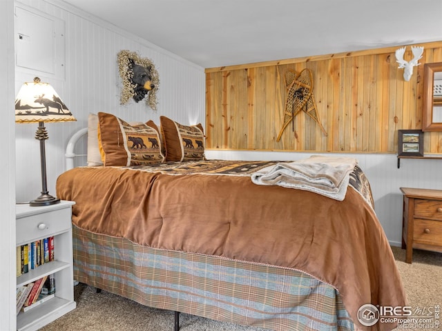 bedroom with carpet flooring and wooden walls