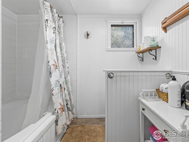 bathroom with shower / bath combo and wooden walls