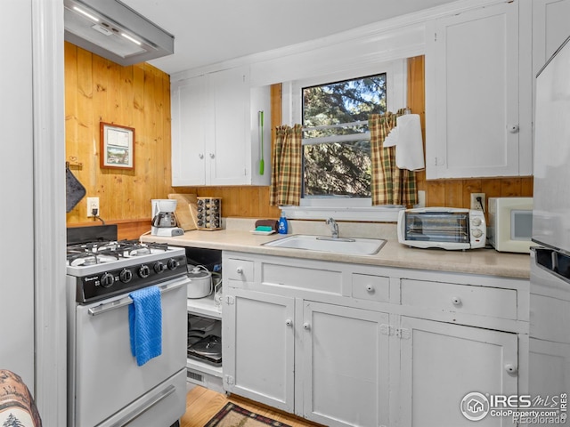 kitchen with white cabinets, range with gas cooktop, and sink