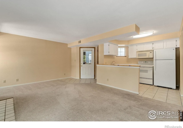 kitchen featuring white cabinetry, sink, white appliances, and light carpet