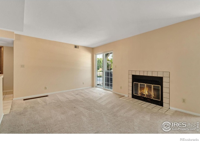 unfurnished living room featuring a fireplace and light colored carpet