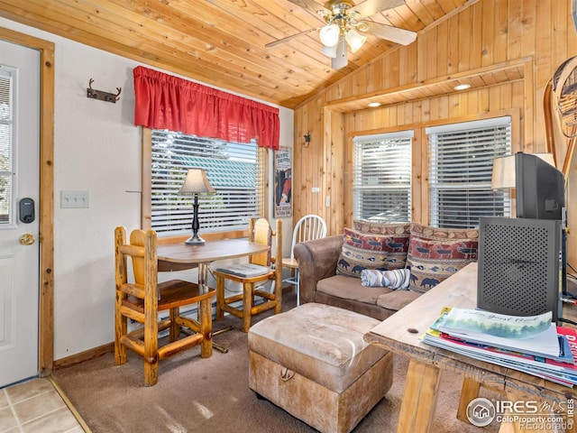 tiled living room with ceiling fan, wood walls, wood ceiling, and lofted ceiling