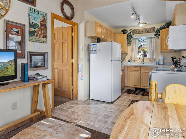 kitchen with light brown cabinetry, light tile patterned flooring, white appliances, and sink