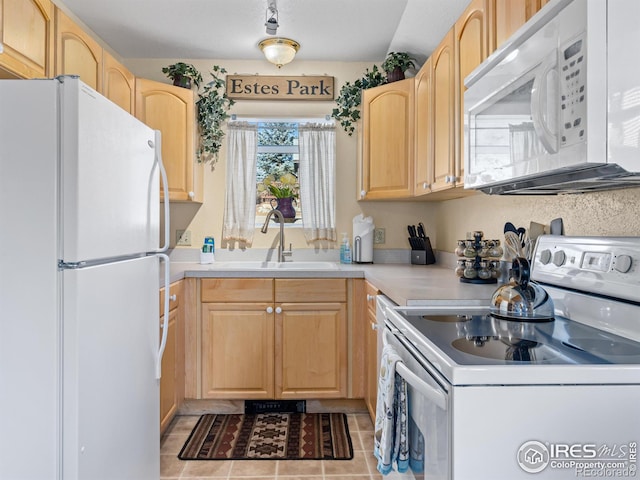 kitchen featuring light brown cabinets, white appliances, and sink