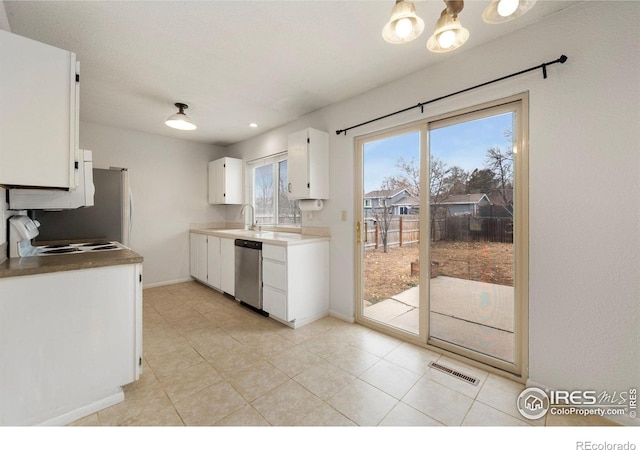 kitchen with sink, light tile patterned floors, white cabinetry, and dishwasher