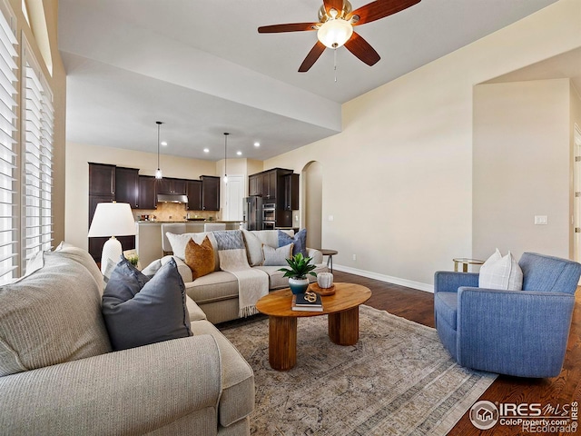 living room with ceiling fan and dark hardwood / wood-style flooring