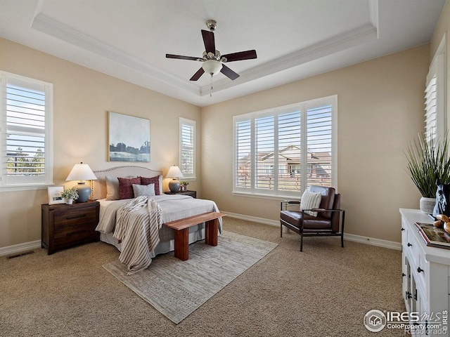 bedroom featuring ceiling fan, a raised ceiling, and light carpet