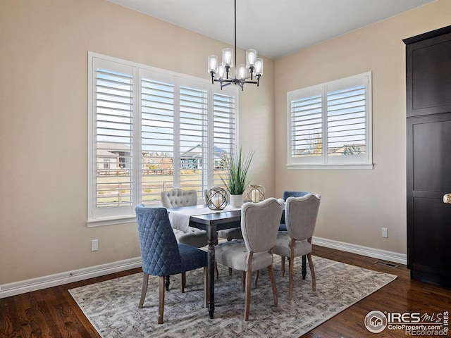 dining room with plenty of natural light, dark hardwood / wood-style floors, and a chandelier